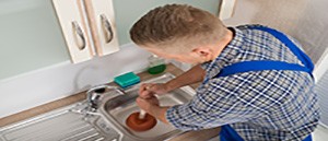 A Man Unblocking A Sink